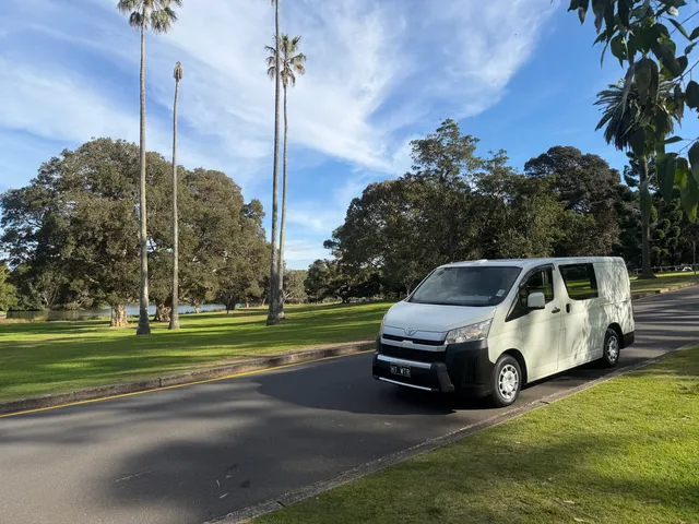 The parked All City Services van in front of a bondi beach